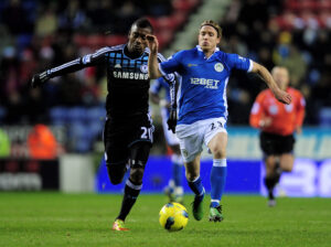 Stam từng có thời gian chơi cho Wigan tại Ngoại Hạng Anh